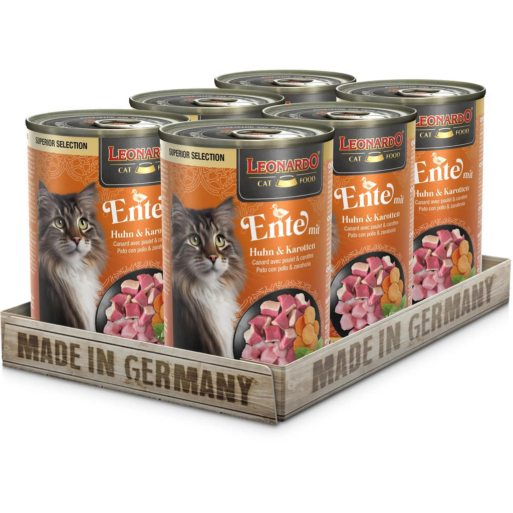 Six cans of Leonardo grain-free wet food for adult cats in a wooden crate, made in Germany, offering high-quality nutrition.