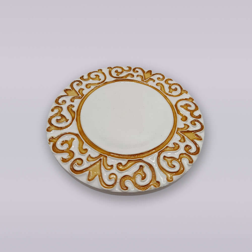 Base de cerâmica redonda com brasão dourado em relevo.